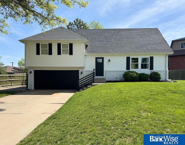 tri-level home with entry steps, an attached garage, driveway, and brick siding