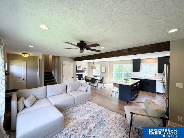 living room featuring recessed lighting, a textured ceiling, light wood-style flooring, stairway, and ceiling fan