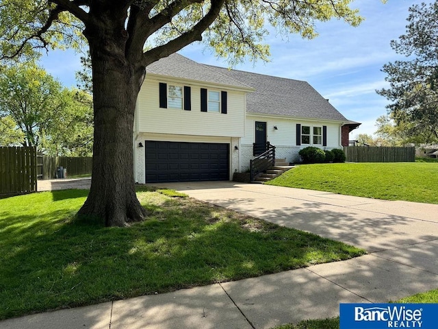 tri-level home featuring a garage, driveway, and brick siding