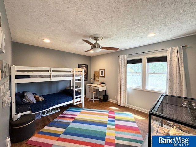 bedroom with wood finished floors, baseboards, a textured ceiling, ceiling fan, and recessed lighting