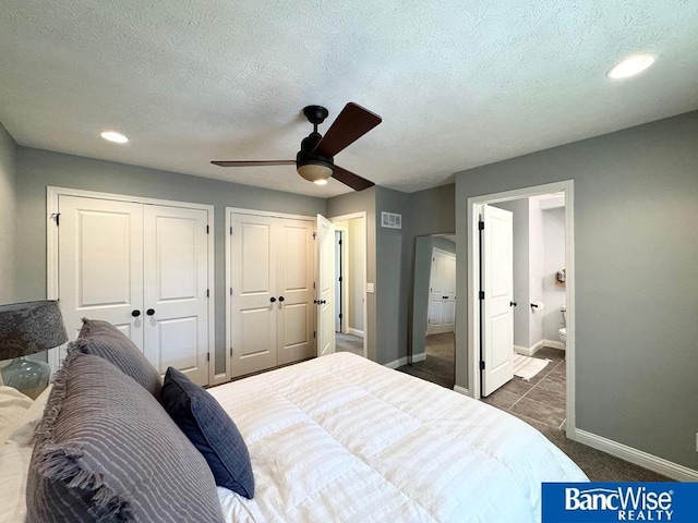 carpeted bedroom with two closets, baseboards, a textured ceiling, recessed lighting, and connected bathroom