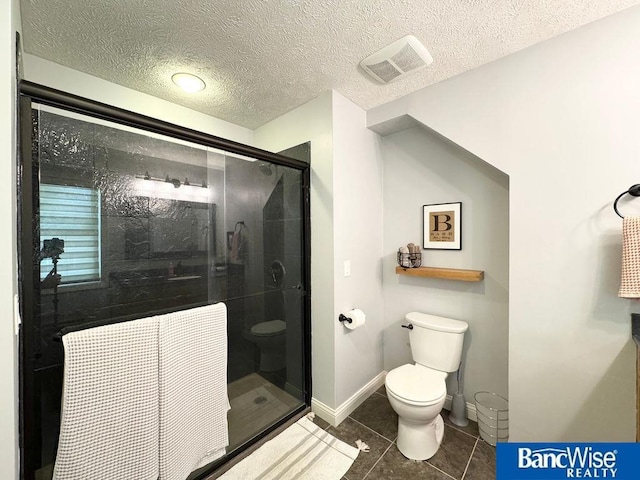 full bath with toilet, a stall shower, tile patterned flooring, a textured ceiling, and baseboards