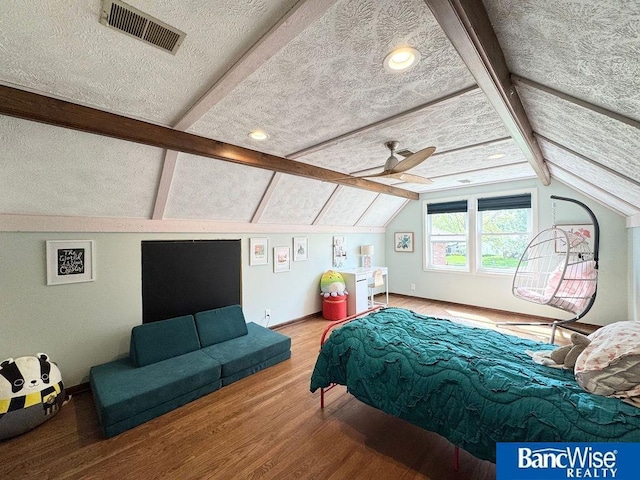 bedroom featuring wood finished floors, a textured ceiling, and baseboards