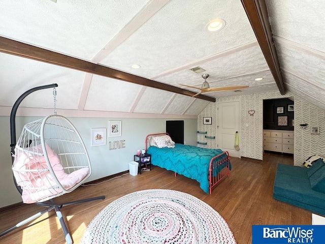bedroom with wood finished floors, baseboards, and a textured ceiling