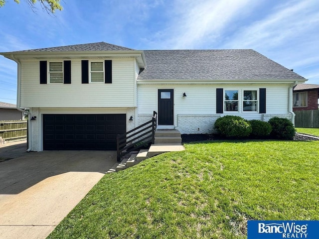 split level home featuring a garage, driveway, entry steps, and roof with shingles