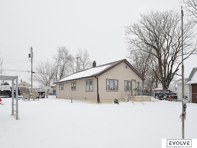 snow covered property with a chimney