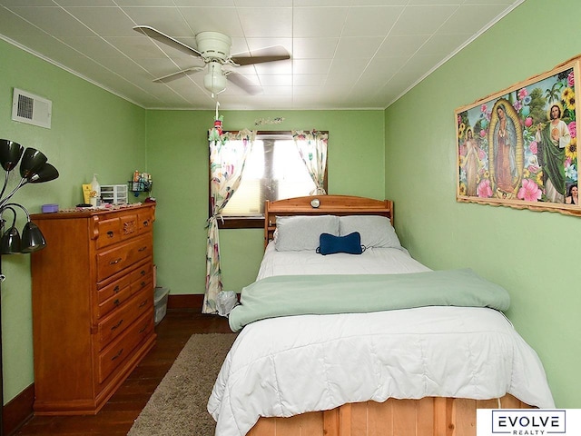 bedroom featuring wood finished floors, ornamental molding, and a ceiling fan