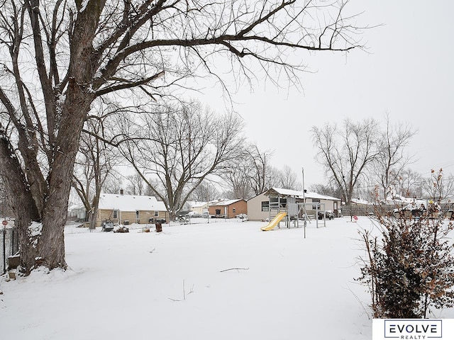 snowy yard featuring a residential view and fence