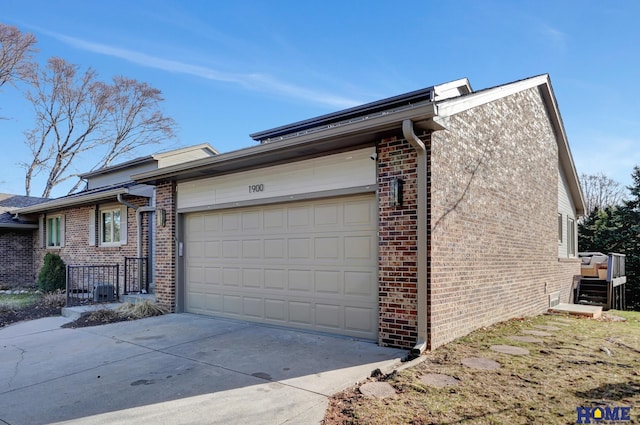 view of property exterior featuring brick siding, a garage, and driveway