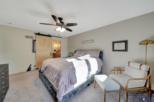 bedroom featuring a barn door, light carpet, and a ceiling fan