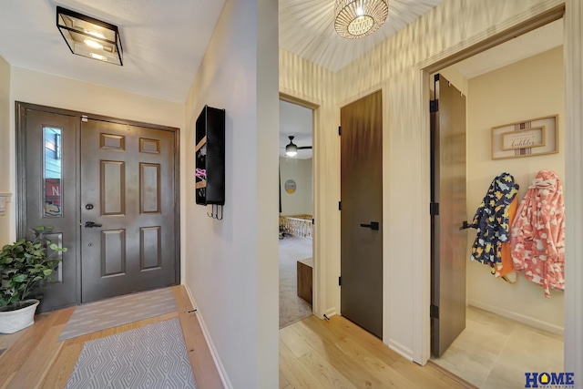 foyer with light wood-style floors and baseboards