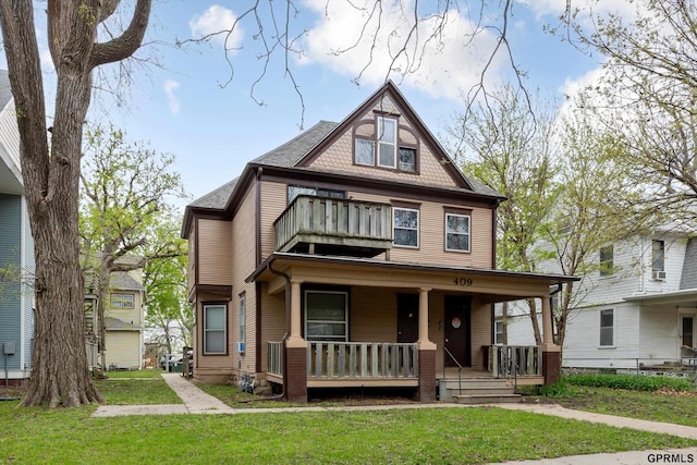 409 N 25th St, Lincoln, NE 68503 - view of front of property with a balcony, covered porch, and a front yard