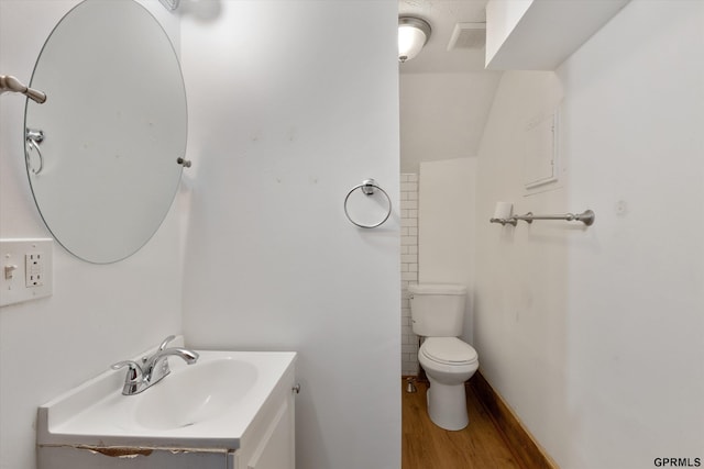409 N 25th St, Lincoln, NE 68503 - bathroom with wood finished floors, vanity, and toilet