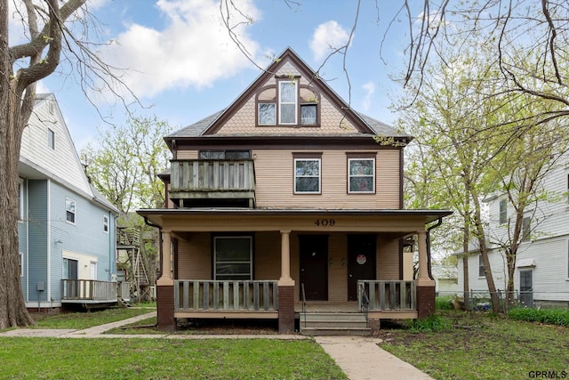 409 N 25th St, Lincoln, NE 68503 - victorian house featuring a porch, a front lawn, and a balcony