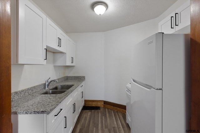 409 N 25th St, Lincoln, NE 68503 - kitchen featuring white appliances, a sink, baseboards, dark wood-style flooring, and white cabinets