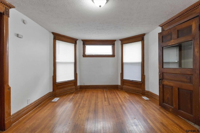 409 N 25th St, Lincoln, NE 68503 - unfurnished room with wood-type flooring, baseboards, and a textured ceiling