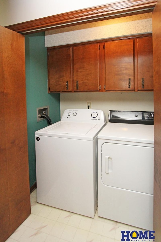 clothes washing area featuring separate washer and dryer and cabinet space