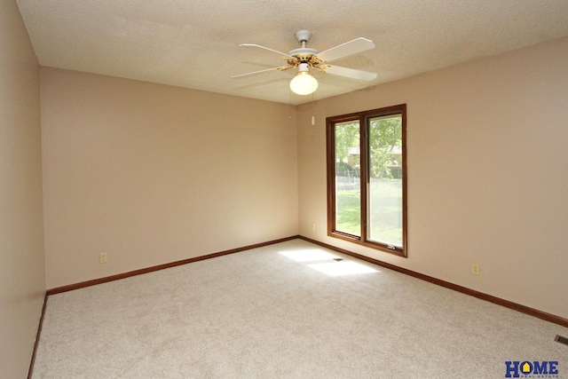 empty room with carpet flooring, ceiling fan, and baseboards