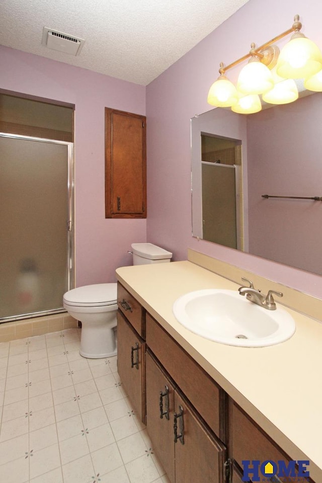 bathroom with a shower stall, vanity, toilet, and a textured ceiling
