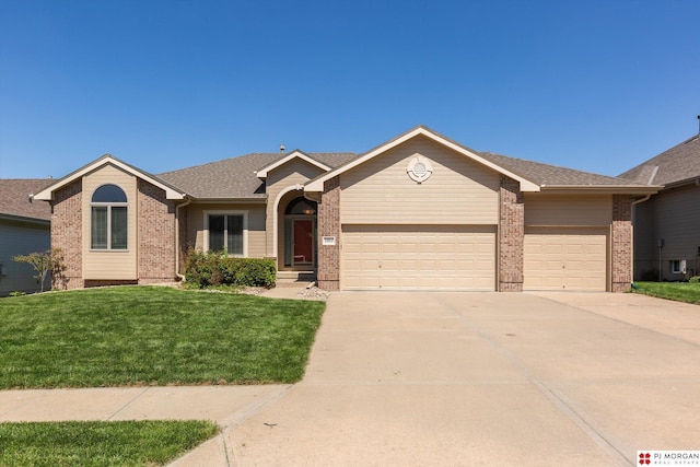 ranch-style home featuring brick siding, an attached garage, concrete driveway, and a front yard