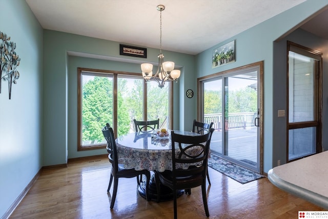 dining space featuring healthy amount of natural light, a chandelier, and wood finished floors