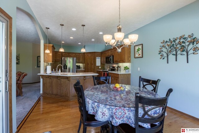 dining space featuring a chandelier, baseboards, light wood-style floors, and recessed lighting