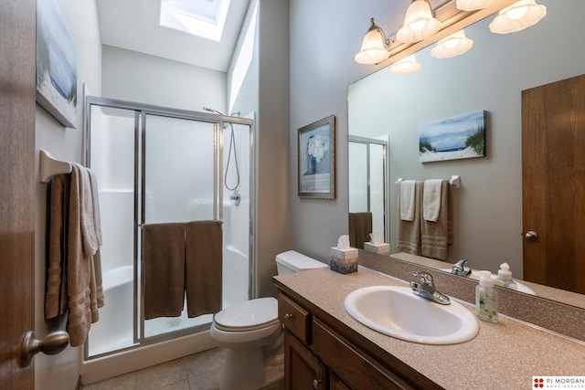 bathroom featuring a stall shower, vanity, a skylight, tile patterned flooring, and toilet