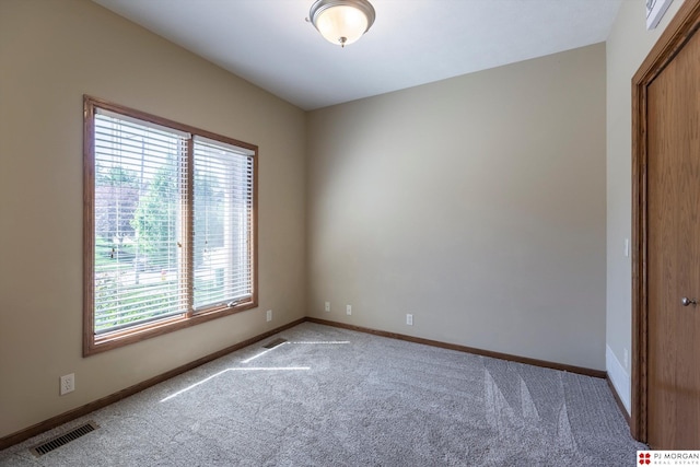 unfurnished room featuring carpet floors and baseboards
