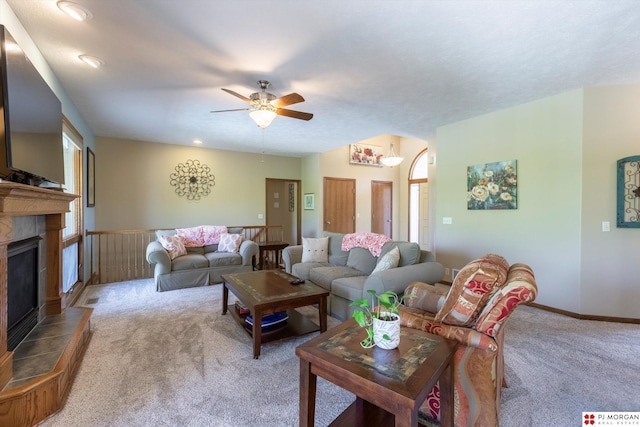 living room featuring carpet, ceiling fan, plenty of natural light, and a tiled fireplace