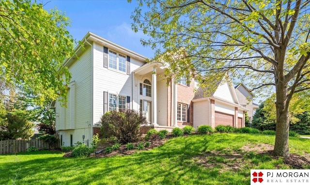 view of front of home featuring fence, an attached garage, and a front lawn