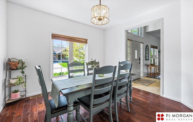 dining space with baseboards, a chandelier, plenty of natural light, and dark wood-type flooring