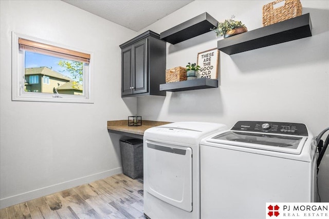 washroom featuring baseboards, light wood finished floors, cabinet space, and washer and clothes dryer
