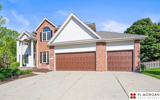 traditional home featuring concrete driveway, a garage, and brick siding