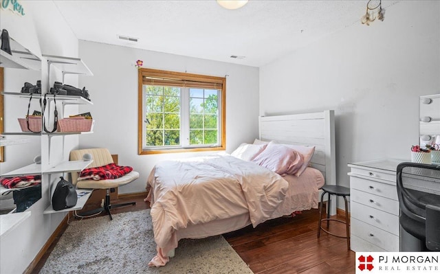 bedroom featuring visible vents and wood finished floors