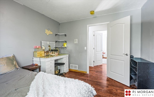 bedroom featuring baseboards, visible vents, and wood finished floors