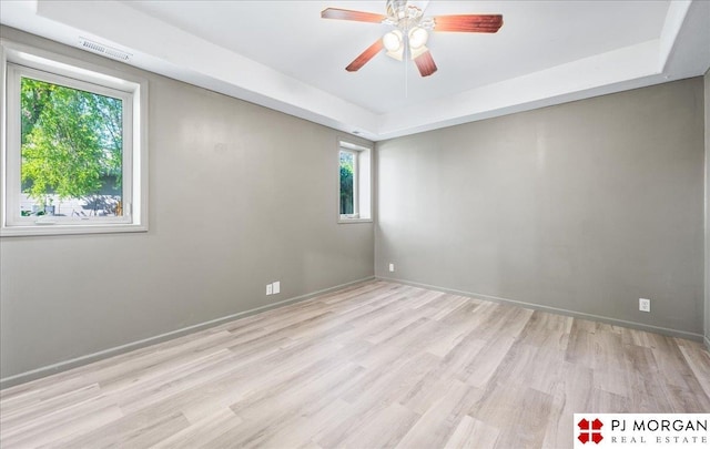 unfurnished room featuring baseboards, a ceiling fan, visible vents, and wood finished floors