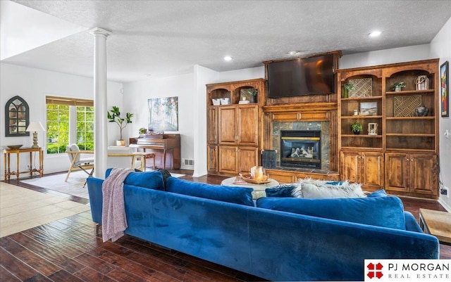 living room with decorative columns, a textured ceiling, visible vents, recessed lighting, and a fireplace