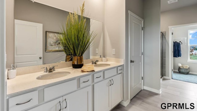 12314 S 204th Ave, Gretna, NE 68028 - full bath featuring double vanity, a shower stall, a closet, baseboards, and wood finished floors