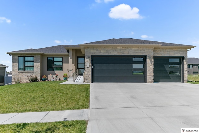 prairie-style house with a garage, stone siding, driveway, and a front yard