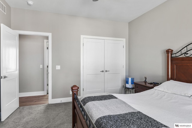 carpeted bedroom with a closet and baseboards