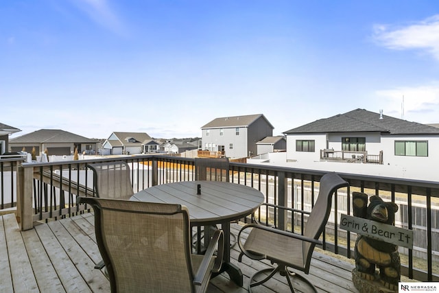 wooden terrace with a residential view and outdoor dining space