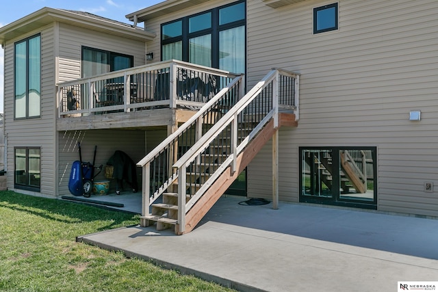 back of property with a patio area, a wooden deck, and a lawn