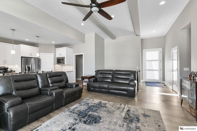 living room with ceiling fan, wood finished floors, recessed lighting, baseboards, and beam ceiling
