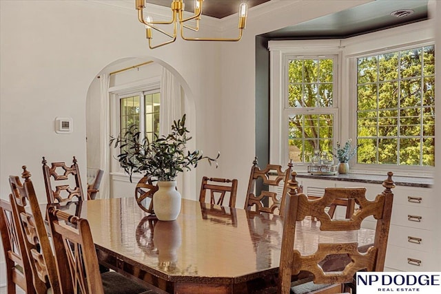 5650 Poppleton Ave, Omaha, NE 68106 - dining space with arched walkways, a chandelier, ornamental molding, and healthy amount of natural light