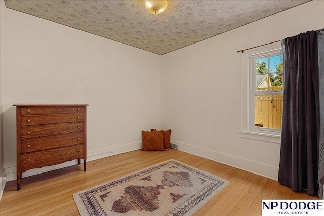 5650 Poppleton Ave, Omaha, NE 68106 - spare room with an ornate ceiling, light wood-style floors, and baseboards