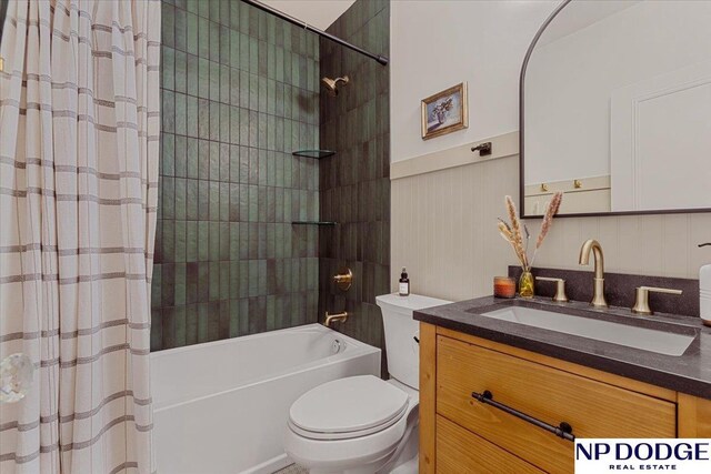 5650 Poppleton Ave, Omaha, NE 68106 - full bathroom featuring toilet, shower / bath combo, vanity, and a wainscoted wall