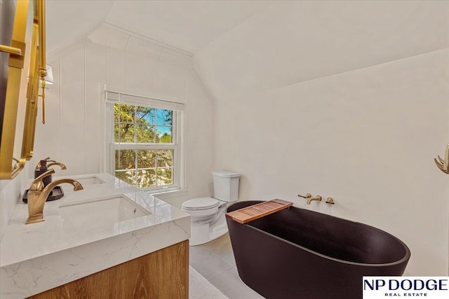 5650 Poppleton Ave, Omaha, NE 68106 - bathroom featuring toilet, a soaking tub, lofted ceiling, tile patterned floors, and vanity