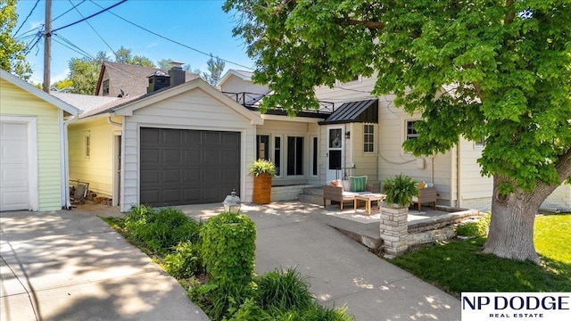 5650 Poppleton Ave, Omaha, NE 68106 - view of front of home featuring a garage, concrete driveway, and a standing seam roof