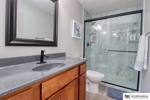 bathroom with vanity, a marble finish shower, and toilet
