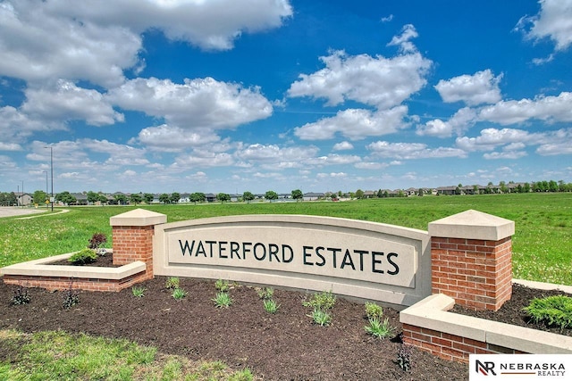 community / neighborhood sign featuring a yard